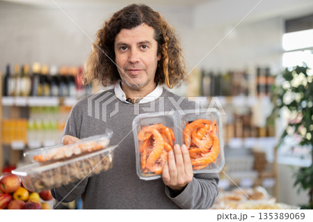 man chooses shrimp and shellfish 135389069