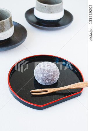 黒いお盆に乗せた和菓子とお茶のセット 135389202
