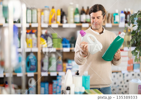 Man choosing cleaning product in supermarket Man choosing cleaning product in supermarket 135389333