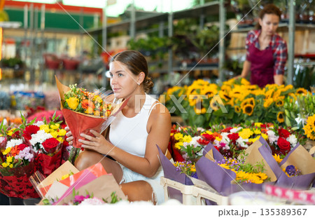 Young woman choosing bouquet of flowers 135389367