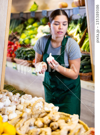 Young woman selling garlic in shop Young woman selling garlic in shop 135389386