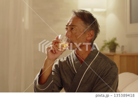 寝室でウイスキーを飲むシニア男性 135389418