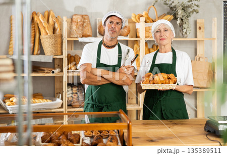 Male and female salesmen posing in bakery with croissants 135389511