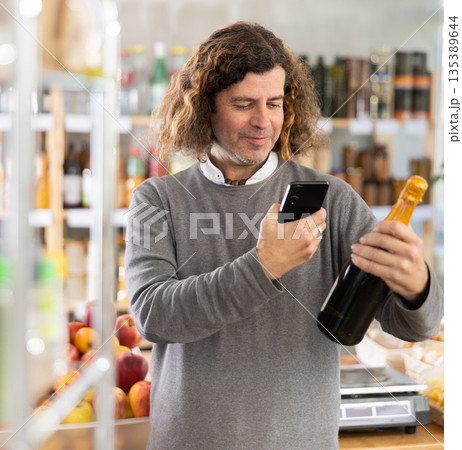 Adult man scanning qr code of champagne Adult man scanning qr code of champagne 135389644