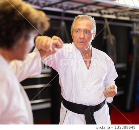 Karate with male athletes practicing, training and sparring in fight class Karate with male athletes practicing, training and sparring in fight class 135389649