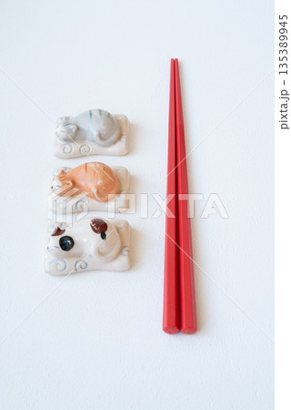 白い背景の赤いお箸と猫のかわいい箸置き 白い背景の赤いお箸と猫のかわいい箸置き 135389945