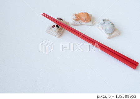 白い背景の赤いお箸と猫のかわいい箸置き 135389952
