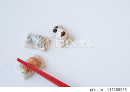 白い背景の赤いお箸と猫のかわいい箸置き 135389956