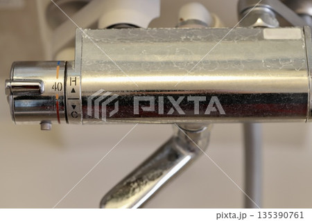 水垢がタップリついた掃除をしていないお風呂場の水栓 135390761