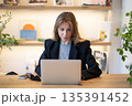 Relaxed business woman working on laptop in casual cafe, typing information or doing research. 135391452