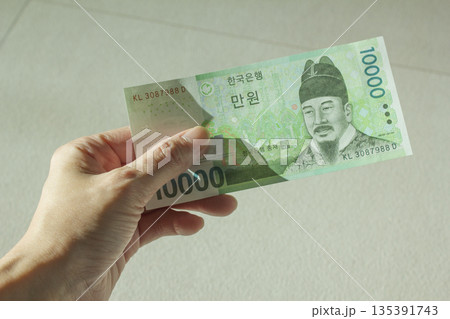A woman's hand holding ten thousand won 135391743