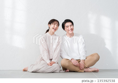 床に座る笑顔の夫婦・カップル 床に座る笑顔の夫婦・カップル 135392538