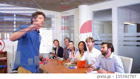 Presenting man in blue shirt, tan pants gesturing toward projected charts at boardroom, copy space 135392707