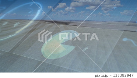 Hovering pac-man data chart overlay moving over farmland, with grid overlay and glowing plus signs 135392947