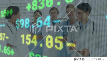 Leading medical team wearing lab coats, discussing data in hospital room, with stock figures 135393007