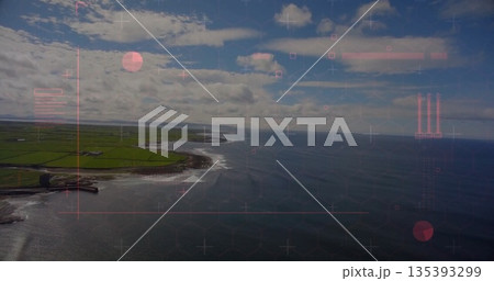 Displaying rocky curved shoreline breaking in coastal farmland, with patchwork fields and ocean 135393299
