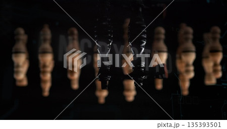 Suspending upside-down glossy black heeled boots in studio, with wooden pawns and digital overlay 135393501