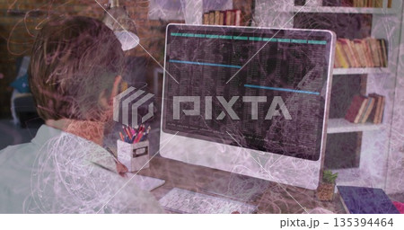 Typing code on monitor, programmer sitting behind wooden desk in home office with lamp, copy space 135394464