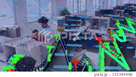 Collaborating analyst and supervisor reviewing monitors in office area, with holographic graphs 135394496