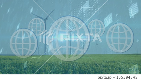Projecting data charts and globe network icons onto green crop field around central wind turbine 135394545