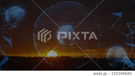 Showing central and smaller wireframe globes hovering over plain at sunset, with blue mesh shapes 135394689