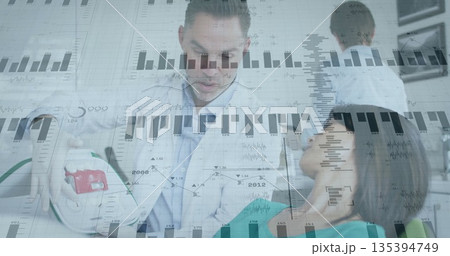 Applying defibrillator paddles, physician in white coat shocking patient in clinic with ECG graphs 135394749