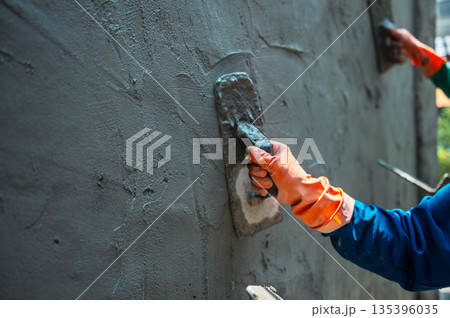 man is painting  wall with  trowel 135396035