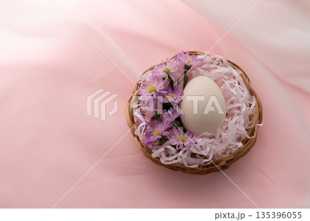 Single Easter Egg in Basket on Pink Background 135396055