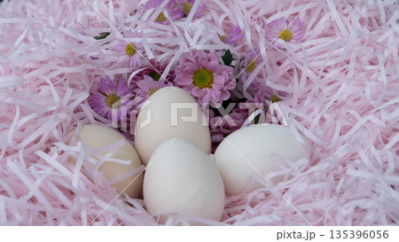 White Easter Eggs in Pink Nest with Flowers White Easter Eggs in Pink Nest with Flowers 135396056
