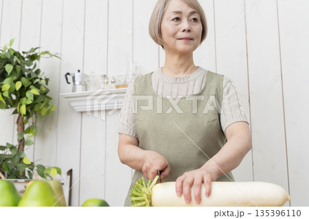 キッチンで楽しく料理をするシニア女性 キッチンで楽しく料理をするシニア女性 135396110