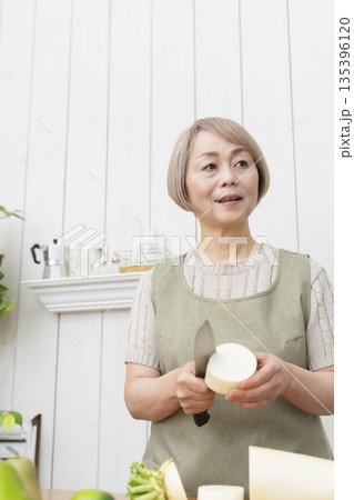 キッチンで楽しく料理をするシニア女性 キッチンで楽しく料理をするシニア女性 135396120