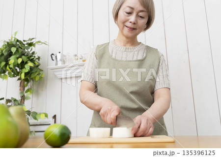 キッチンで楽しく料理をするシニア女性 キッチンで楽しく料理をするシニア女性 135396125