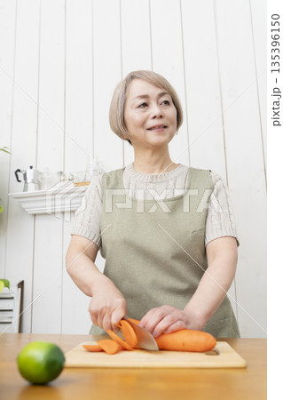 キッチンで楽しく料理をするシニア女性 キッチンで楽しく料理をするシニア女性 135396150