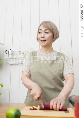 キッチンで楽しく料理をするシニア女性 135396157