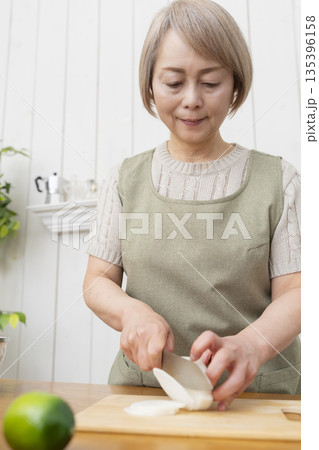 キッチンで楽しく料理をするシニア女性 135396158