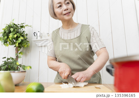キッチンで楽しく料理をするシニア女性 キッチンで楽しく料理をするシニア女性 135396165
