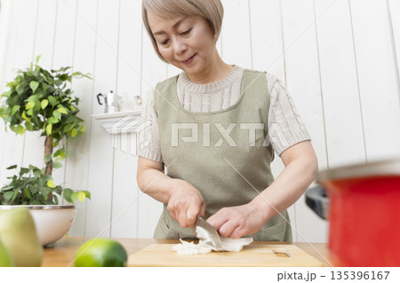 キッチンで楽しく料理をするシニア女性 135396167