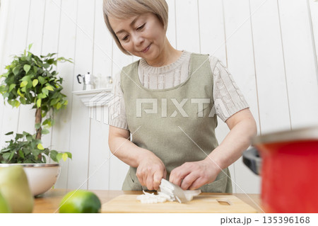 キッチンで楽しく料理をするシニア女性 135396168