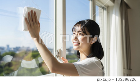 年末の大掃除 窓拭き掃除を頑張る女性 年末の大掃除 窓拭き掃除を頑張る女性 135396226