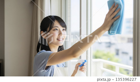 年末の大掃除 窓拭き掃除を頑張る女性 年末の大掃除 窓拭き掃除を頑張る女性 135396227