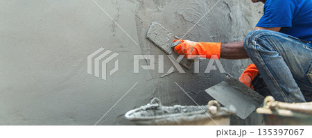 man is laying  brick wall with  trowel 135397067