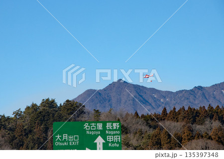 山の上を飛ぶ消火用ヘリコプター 135397348