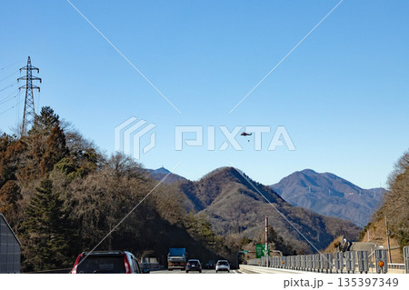 山の上を飛ぶ消火活動中のヘリコプター 135397349