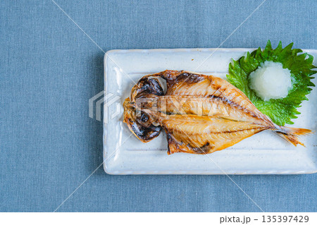 白い角皿に盛り付けた鯵の開き 大根おろしと大葉添え 白い角皿に盛り付けた鯵の開き 大根おろしと大葉添え 135397429