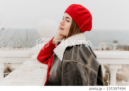 Woman beret jacket, young stylish woman relaxing on a coastal promenade. Woman beret jacket, young stylish woman relaxing on a coastal promenade. 135397494