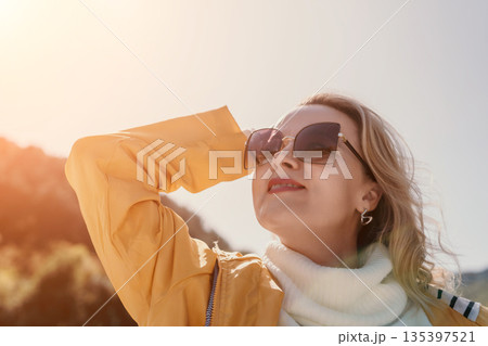 Woman Sunglasses Sunshine - Portrait of a woman wearing sunglasses in bright sunshine. Woman Sunglasses Sunshine - Portrait of a woman wearing sunglasses in bright sunshine. 135397521
