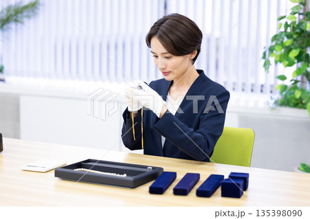 買取業者 窓口で査定をしている女性 買取業者 窓口で査定をしている女性 135398090