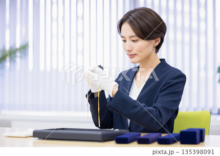 買取業者　窓口で査定をしている女性 135398091