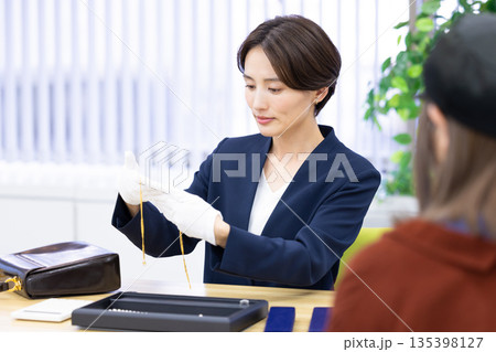 買取業者 窓口で査定をしている女性 買取業者 窓口で査定をしている女性 135398127