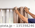 Handyman repairman hanging and fixing the curtain rod on the window 135398246